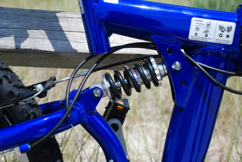 Shock of a blue folding bicycle.