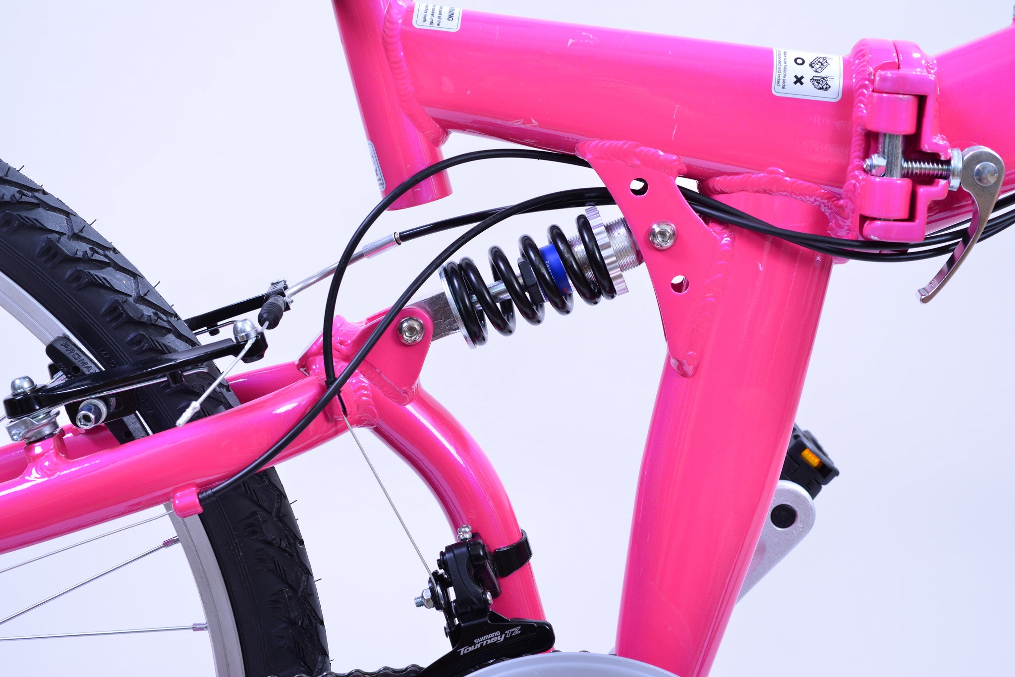 View of the spring of a foldable pink bicycle.
