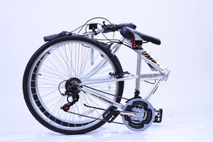Silver folding bike in a folded position sitting on the ground.