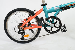 Rear wheel of an orange and blue folding bicycle.