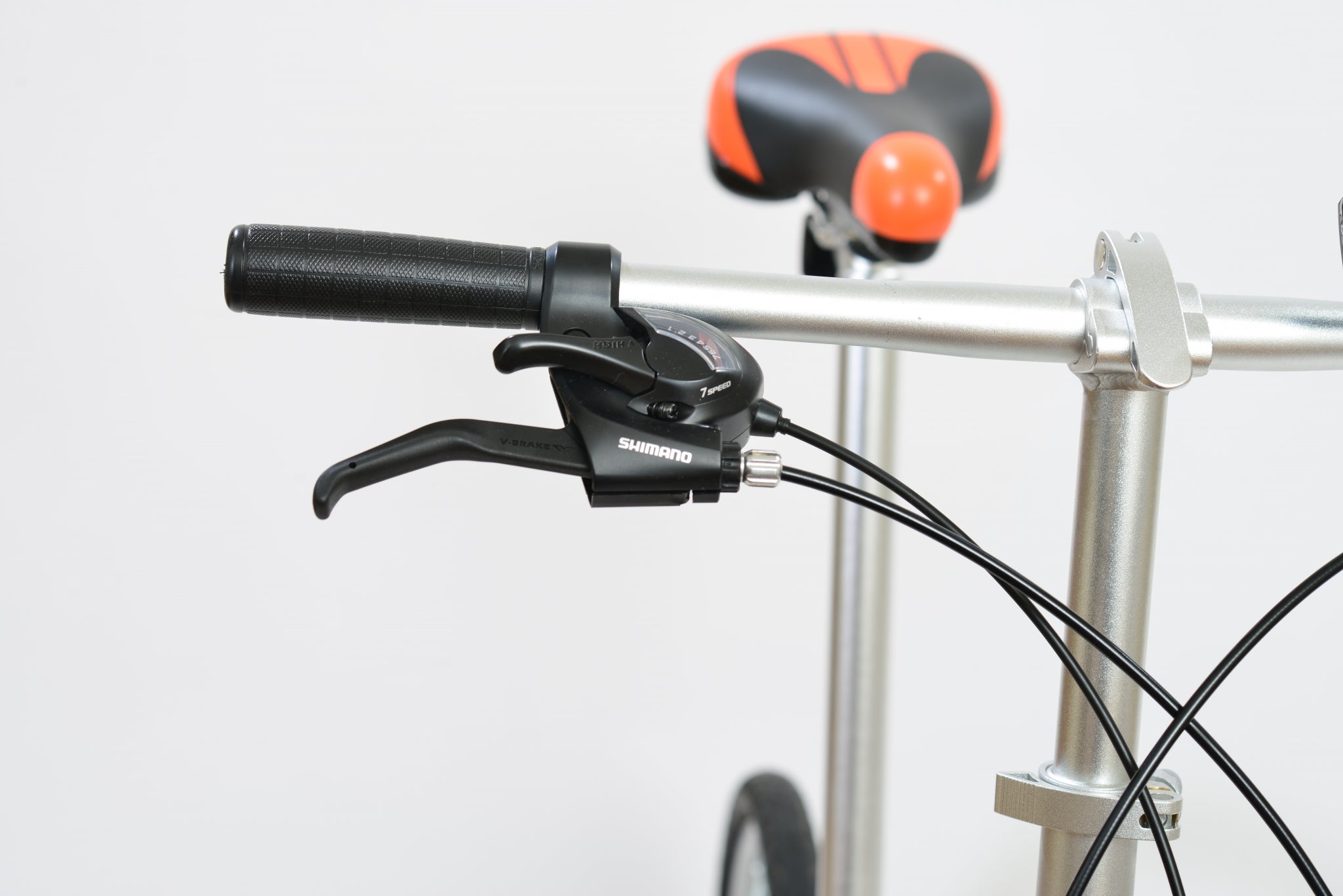 Right handlebar of a folding bicycle with a black and orange seat post.