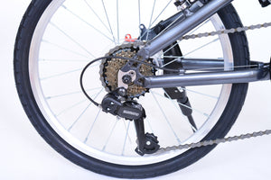 Rear derailleur of a gray folding bicycle.
