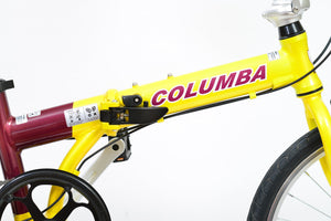Close up side view of hinge and tube of a yellow and purple folding bicycle.