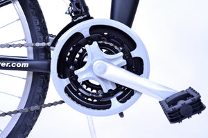 Bike crank and pedal on a black bike.