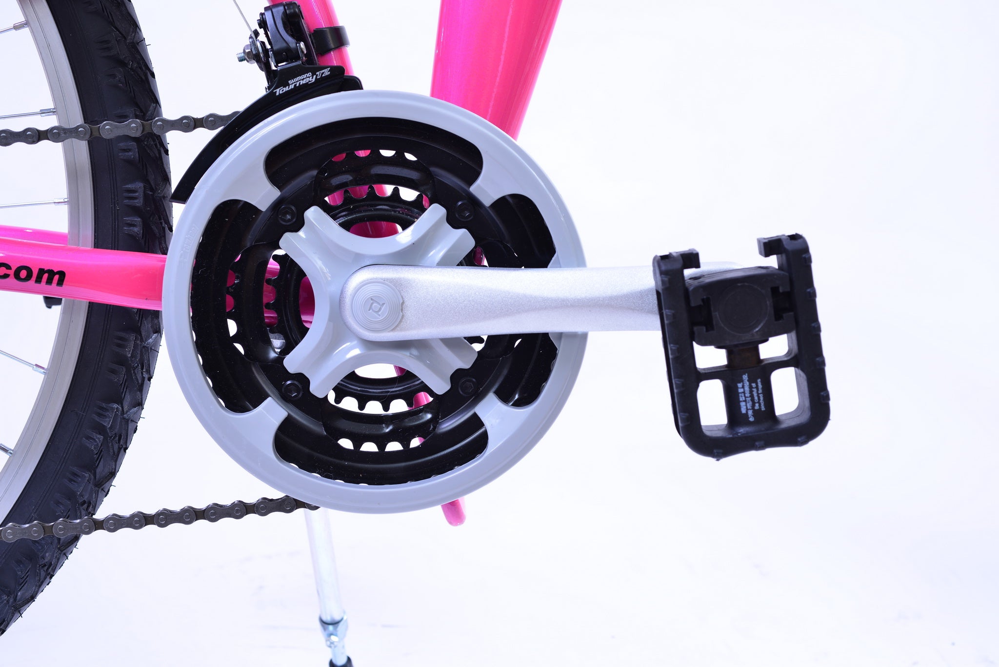 Foldable pedal on a crank arm of a bright pink bicycle.