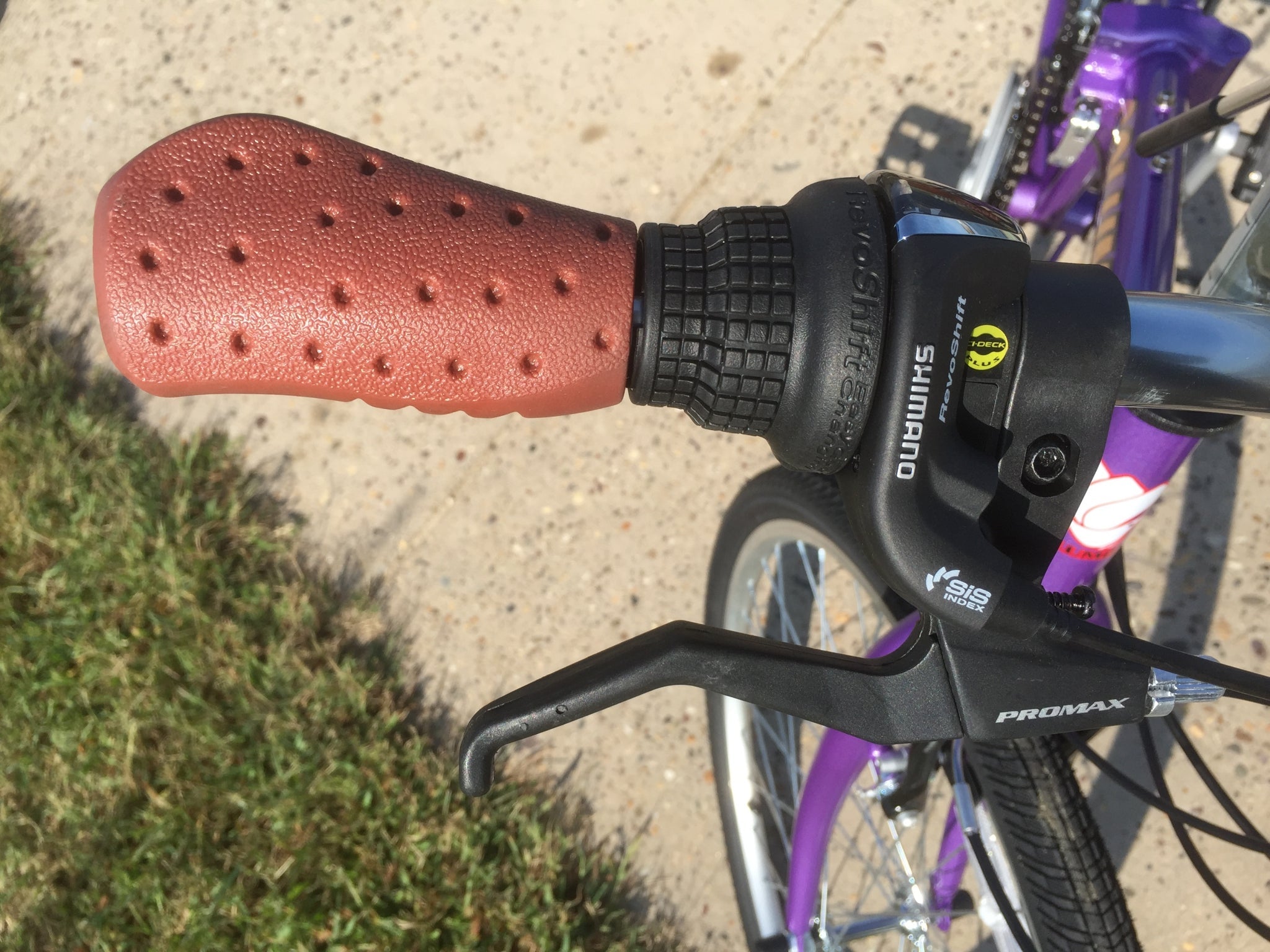Right handlebar of a purple folding bicycle.